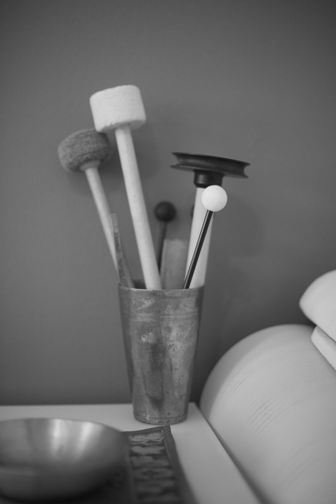 Diverse Schlägel vor einer Klangschale.