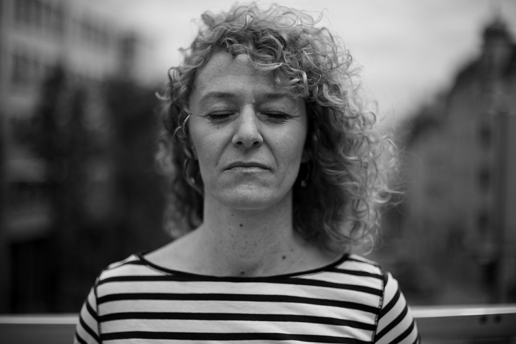 Vicky mit geschlossenen Augen mit München im Hintergrund.