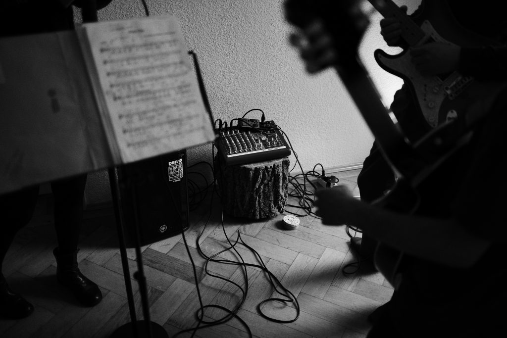 Bandprobe mit Gitarre, Notenständer und Mischpult.