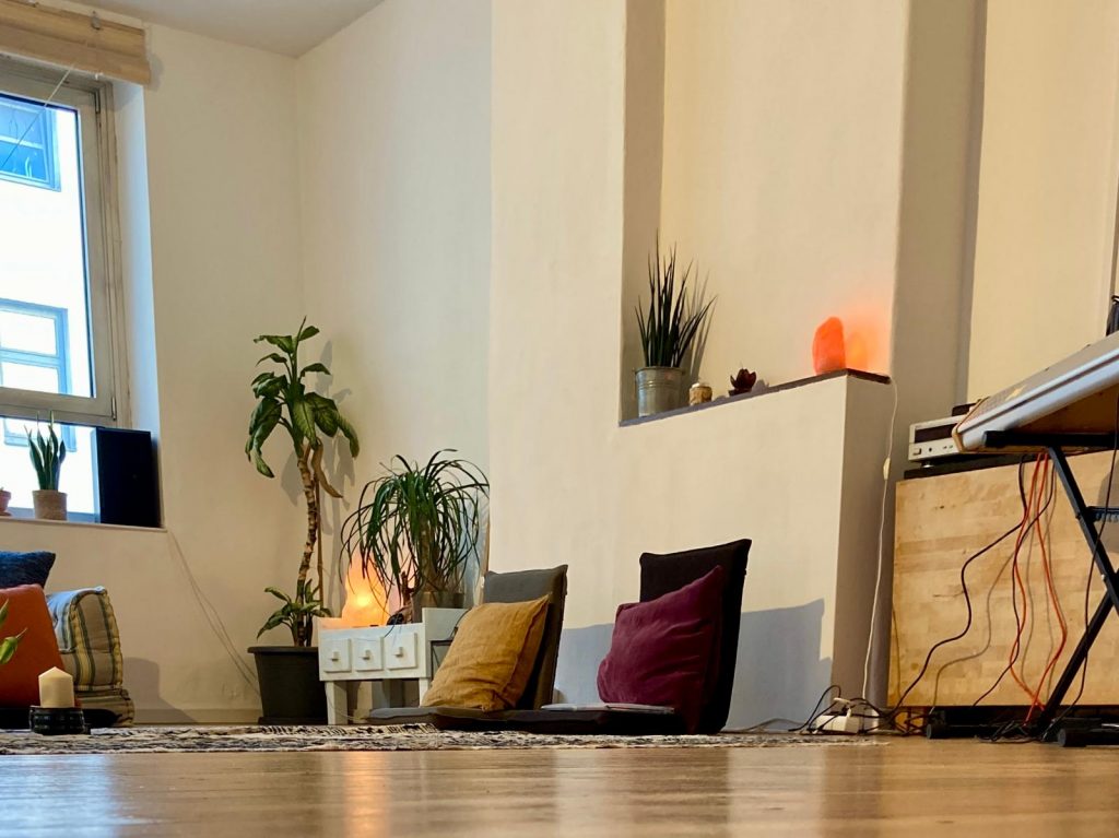 Seminarraum mit Bodenstühlen, Pflanzen und Klavier.